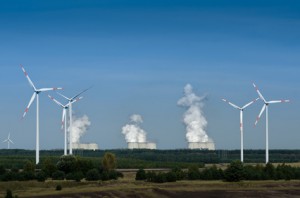 Windräder vor einem Kohlekraftwerk mit CO2-Emissionen