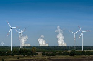 Windräder vor einem Kohlekraftwerk mit CO2-Emissionen